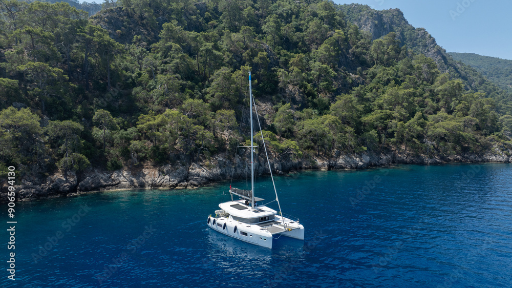 Aerial view of a catamaran sailing smoothly on the clear waters.
Aerial view of a catamaran sailing smoothly on the clear waters.