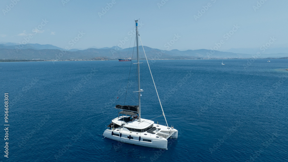 Stunning drone shot of a catamaran navigating the open sea Stunning drone shot of a catamaran navigating the open sea