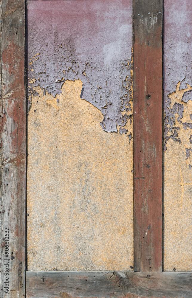 Naklejka premium Detail of a half-timbered house with a layer of purple and yellow paint
