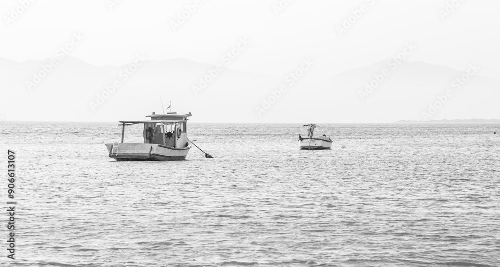 Dois barcos ancorados o mar. Fotografia em preto e branco. Mar calmo. Propaganda de embarcações, sites, websites. Apresentação com espaço para escrita. Dois barcos ancorados o mar. Fotografia em preto e branco. Mar calmo. Propaganda de embarcações, sites, websites. Apresentação com espaço para escrita.