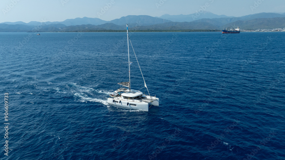 Fototapeta premium catamaran sailing gracefully, captured by a drone.