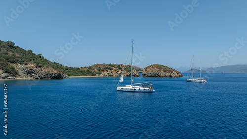 Stunning drone shot of a sailing boat gliding under the clear blue sky