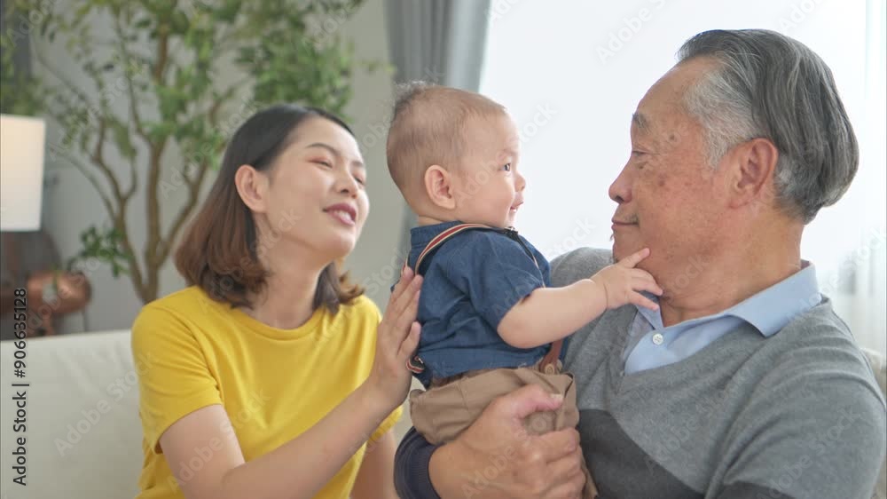 A tiny child smiling happily on the couch in the living room with mom and grandfather A tiny child smiling happily on the couch in the living room with mom and grandfather