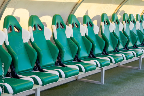 Empty coach and reserves green bench on a football stadium photo