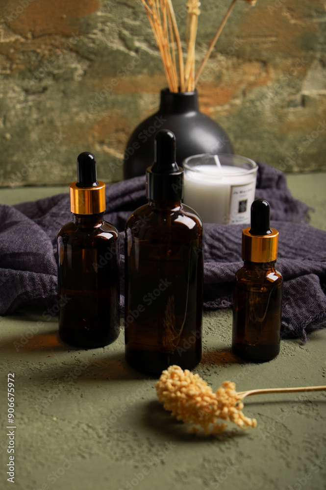 Naklejka premium Amber Dropper Bottle with Dried Flowers and Candle