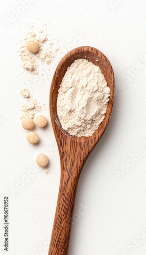 A wooden spoon filled with flour, surrounded by scattered flour and soybeans, showcasing natural ingredients for cooking. photo