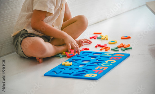 Child playing with colorful alphabet puzzle on the floor, engaging in fun educational activity, promoting learning through play.