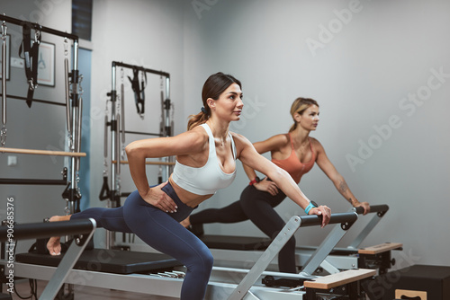 Young women exercising in a gym on pilates machines.