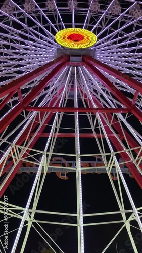 Izmit, Kocaeli, Turkey, 03 September 2022, Ferris Wheel at Kocaeli Fair. Gulf Sun. Famous Night View. A colourful ferris wheel spinning slowly in an amusement park at night. Turkish: Körfez Güneşi. photo