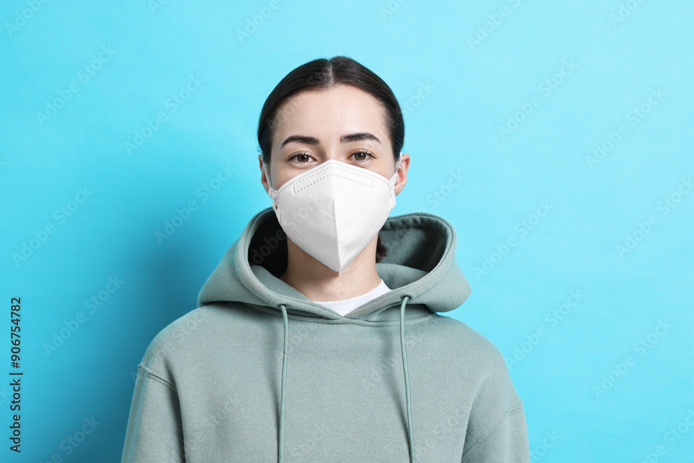 Woman in respirator mask on light blue background Woman in respirator mask on light blue background