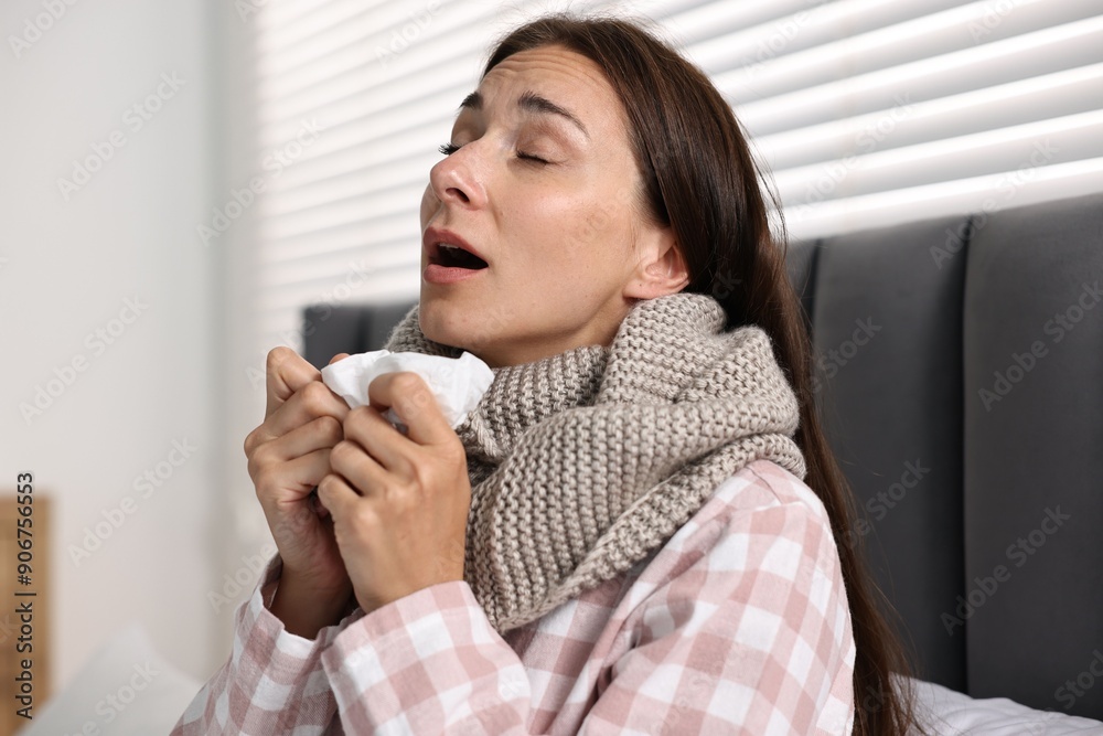 Sick woman with tissue sneezing in bed. Cold symptoms Sick woman with tissue sneezing in bed. Cold symptoms
