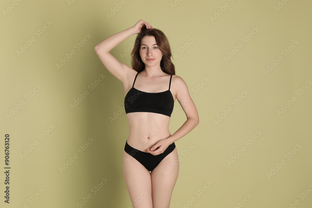 Fototapeta premium Woman with slim body posing on olive background