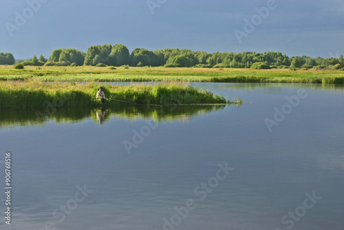 quiet day on the river bank, fisherman on the bank