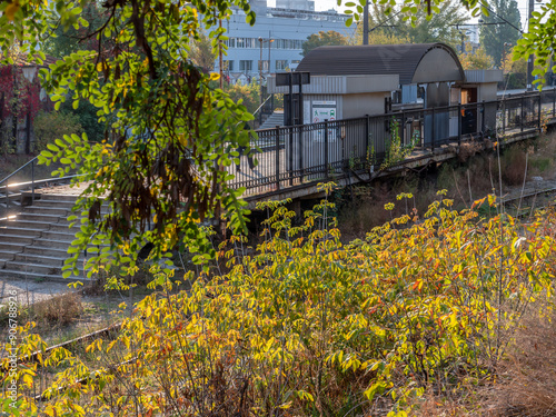 Obraz na płótnie Suburban city train station with concrete platform and metal shed. Autumn colorful morning. w salonie