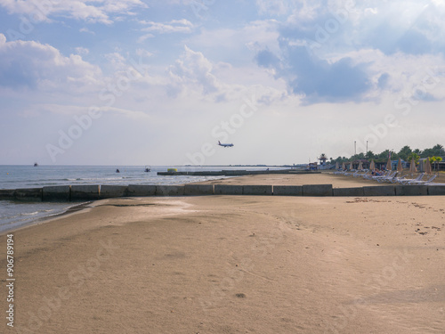 Obraz na płótnie Airplane low above blue Mediterranean sea with wave breakers and sandy beach flying to Larnaca airport, Cyprus. Ships on the horizon. w salonie