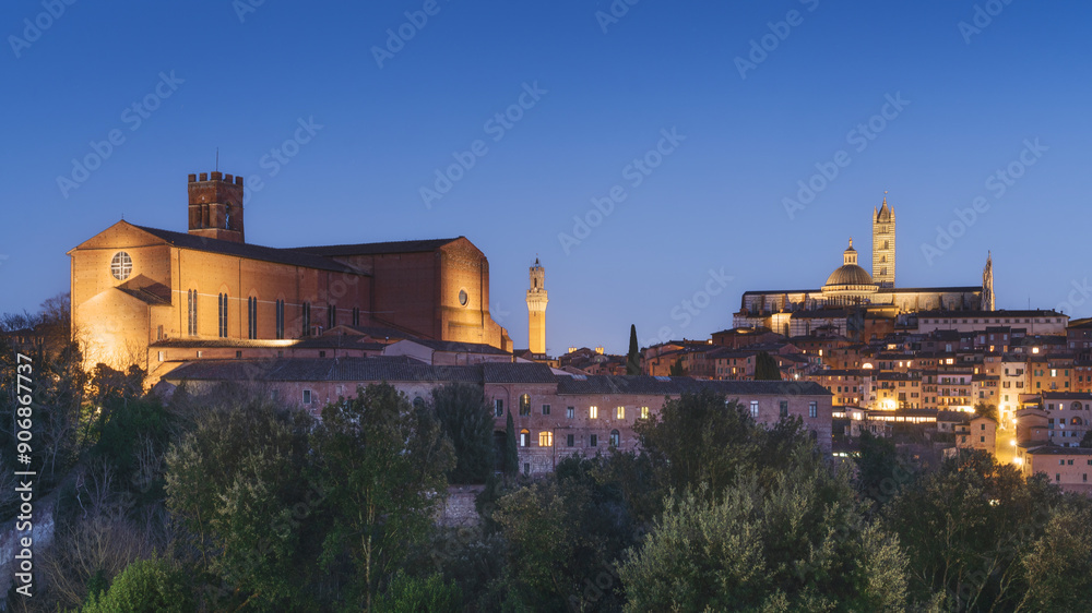 Fototapeta premium Blue hour over Siena skyline. San Domenico, Mangia tower, and cathedral. Italy