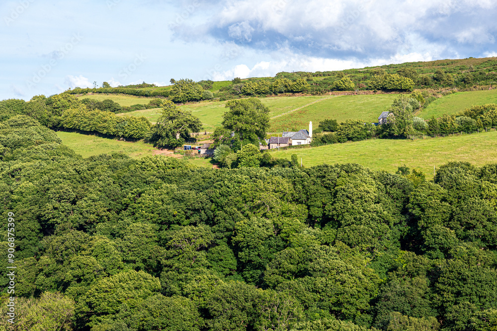 Obraz premium The tiny, remote farm & church at Stoke Pero (the highest church on Exmoor), Somerset UK - viewed across the wooded valley from Wilmersham