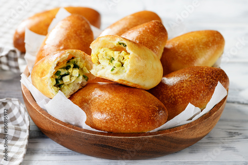 Freshly baked patties ( russian piroshki ) with egg and green onion stuffing.