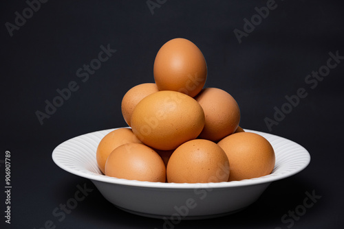 White plate with arrangement of raw chicken eggs. Raw chicken eggs for cooking purposes.