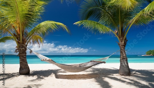 Relaxing hammock between two palm trees on a tropical beach with white sand and blue ocean in the background.