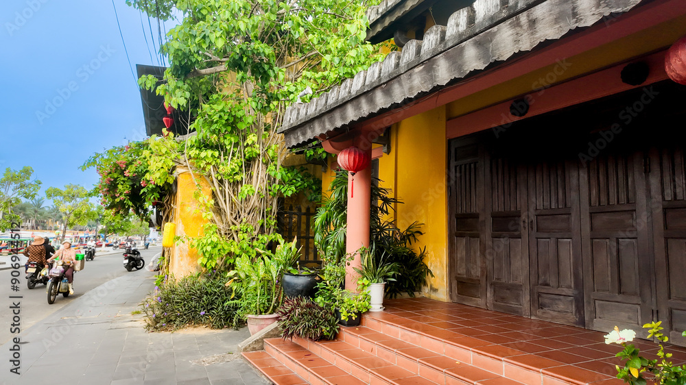 Bright yellow Vietnamese house with red lanterns, lush plants, and motorbikes on the street, ideal for Tet holiday celebration Bright yellow Vietnamese house with red lanterns, lush plants, and motorbikes on the street, ideal for Tet holiday celebration