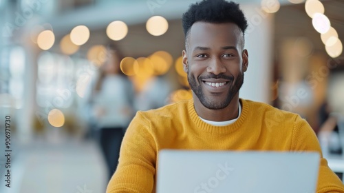 Smiling Man Working on Laptop in Cozy Modern Cafe During Daylight Hours