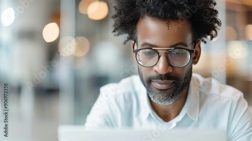 Smiling Man Working on Laptop in Modern Office During Daytime
