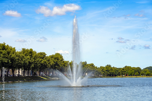 Fototapeta Naklejka Na Ścianę i Meble -  Large fountain on the city lake Pfaffenteich, one of the seven lakes in Schwerin, tourism and travel destination, blue sky with clouds, copy space, selected focus