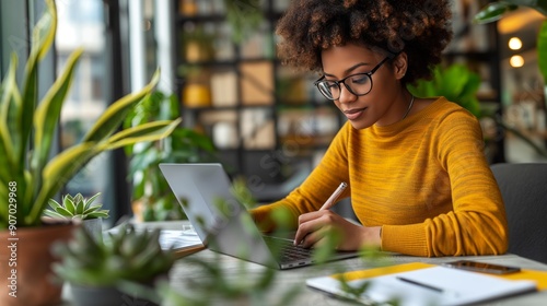 Young Professional Working in Cozy Green Office - Writing Notes and Using Laptop
