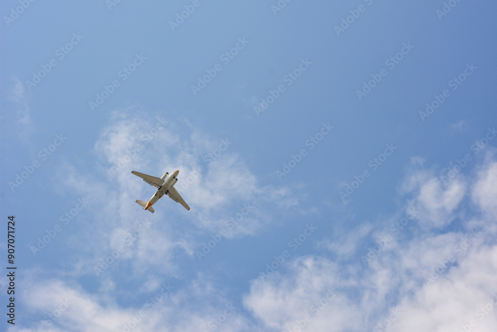 A passenger plane flies high in the blue sky with light clouds. A passenger plane flies high in the blue sky with light clouds.