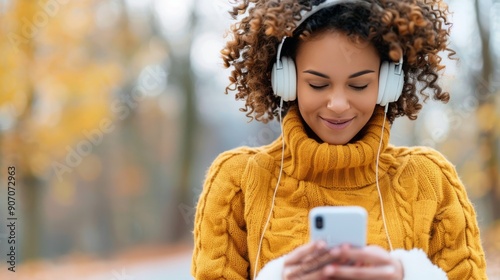 Young Woman Enjoying Music Outdoors in Autumn While Using Smartphone