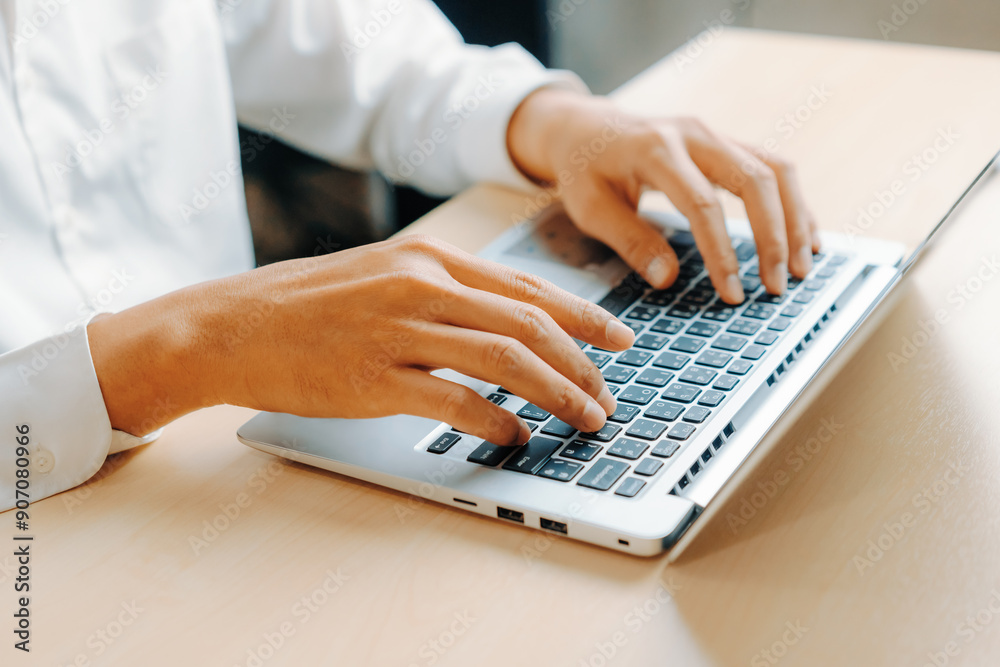 Businessman hand typing on computer keyboard of a laptop computer in office. Business and finance concept. uds Businessman hand typing on computer keyboard of a laptop computer in office. Business and finance concept. uds