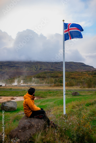 Obraz na plátně man on the mountain looking at the icelandic flag