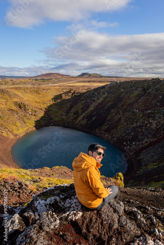 hiker on the edge of kerid, the volcano crater in iceland