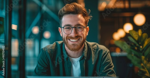 Portrait of happy young businessman working on his laptop