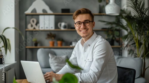Portrait of happy young businessman working on his laptop