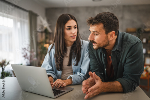 Wallpaper Mural adult caucasian couple stand and use, study learn on laptop at home Torontodigital.ca