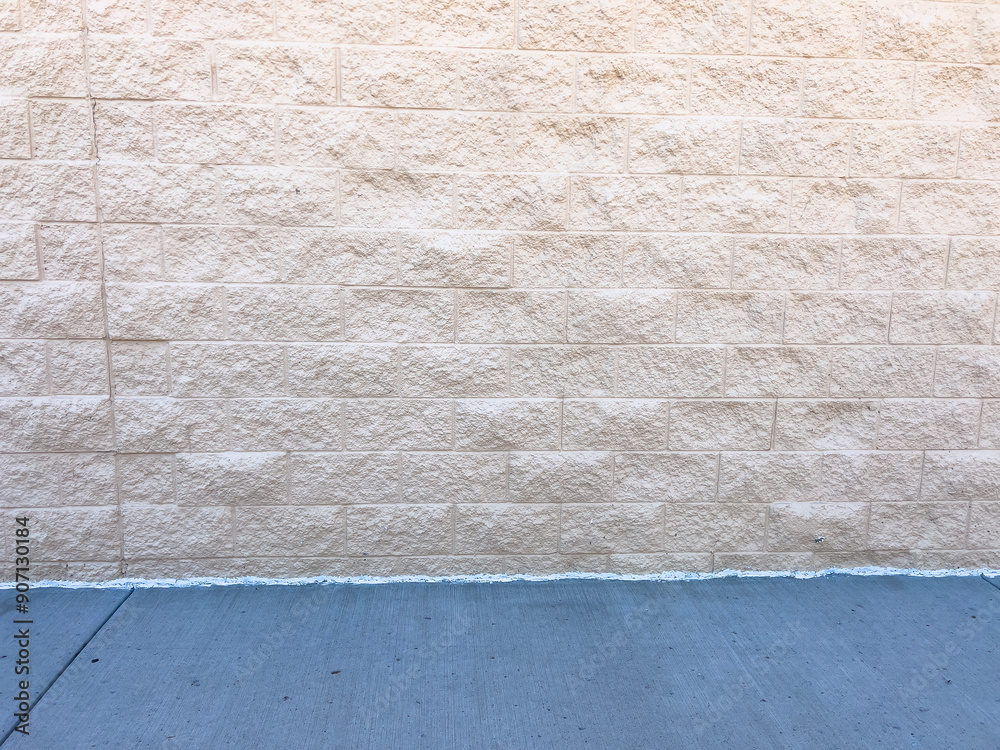Beige Brick Wall with Clean Concrete Sidewalk Beige Brick Wall with Clean Concrete Sidewalk