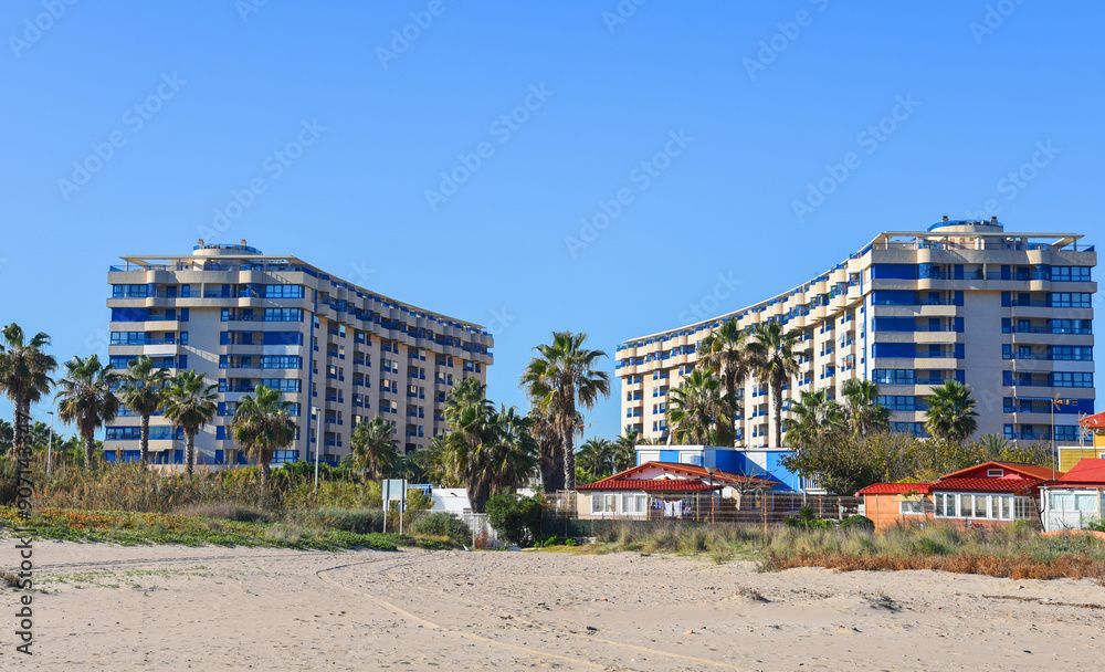 Facade building with palm trees. Beach at sea near apartments Facade building with palm trees. Beach at sea near apartments