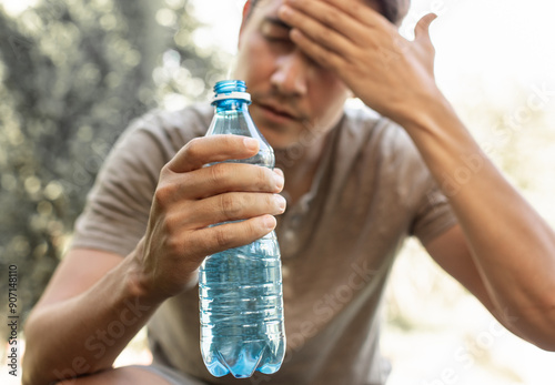 Quadro su tela Man drinking water in extreme summer heat, person drinks from water bottle reple