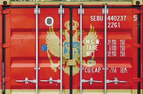 Montenegro flag depicted on metal doors of shipping cargo container outdoors in docks area close up photo