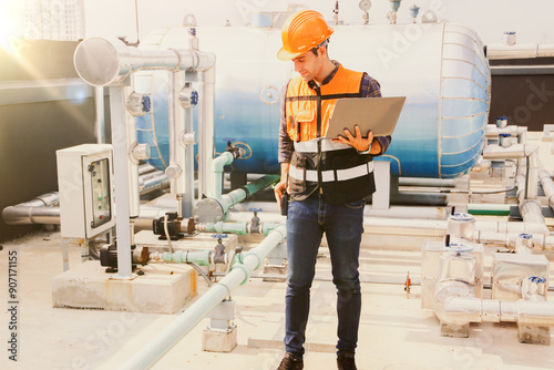 Portrait male HAVC refrigeration system technician holding laptop preventive inspection refrigeration equipment low pressure tanks contain refrigerant into the system and checked leaks ensure safety.
