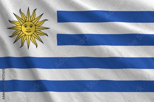 Uruguay flag depicted on folded wavy fabric of old cloth close up photo