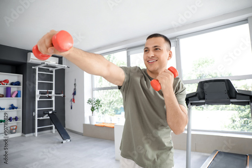Smiling young man exercisin...