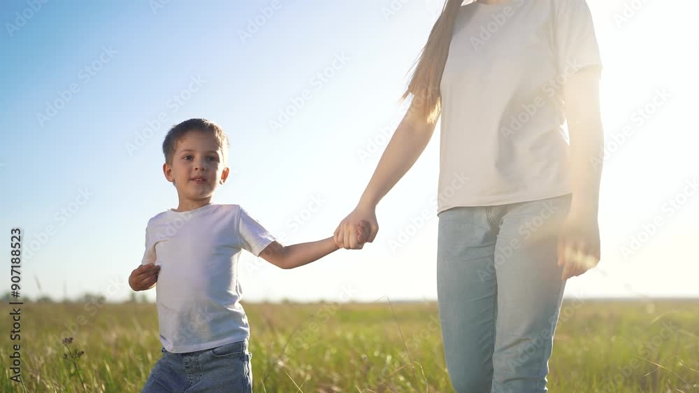 beautiful mother and son are walking. people outside family and nature concept. young mother walks holding hands with her beautiful son in the park on a lifestyle sunny day beautiful mother and son are walking. people outside family and nature concept. young mother walks holding hands with her beautiful son in the park on a lifestyle sunny day
