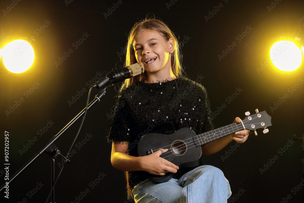 Little girl with ukulele and microphone singing on dark background Little girl with ukulele and microphone singing on dark background