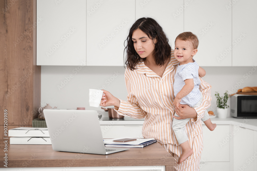 Working mother with coffee cup and her little baby in kitchen Working mother with coffee cup and her little baby in kitchen