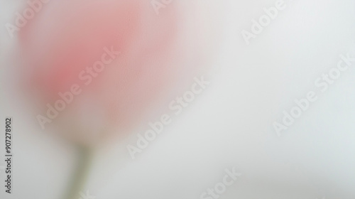 Behind the glass, the subtle suggestion of a tulip is softly discernible - a blurred pink shape with no definable details photo