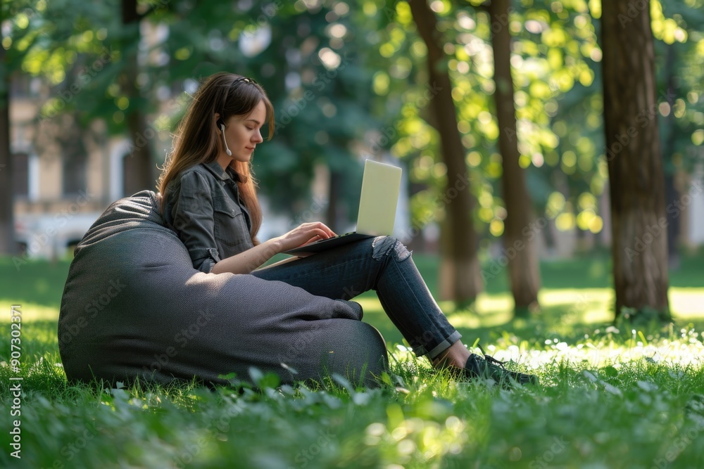 A woman sits comfortably on a bean bag with a laptop, perfect for remote work or study A woman sits comfortably on a bean bag with a laptop, perfect for remote work or study