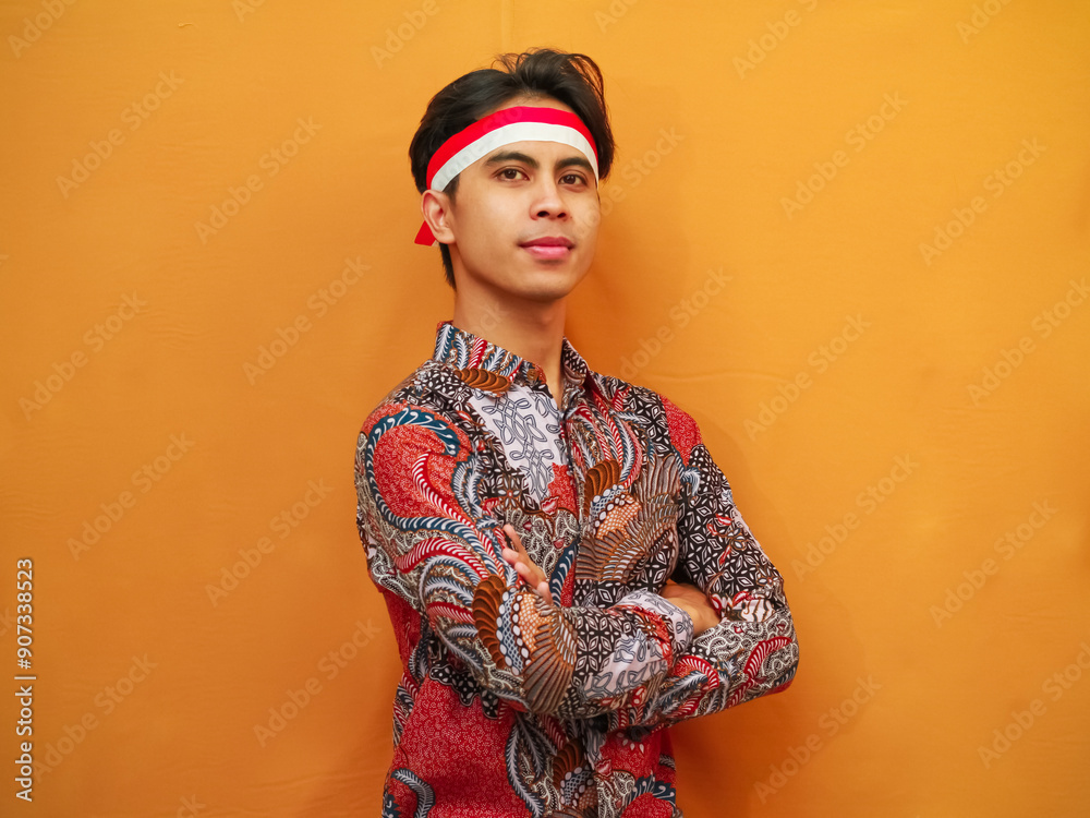 Handsome Indonesian man in Batik shirt celebrating Indonesian Independence Day on August 17 concept, posing with confident dashing and looking at the camera Handsome Indonesian man in Batik shirt celebrating Indonesian Independence Day on August 17 concept, posing with confident dashing and looking at the camera